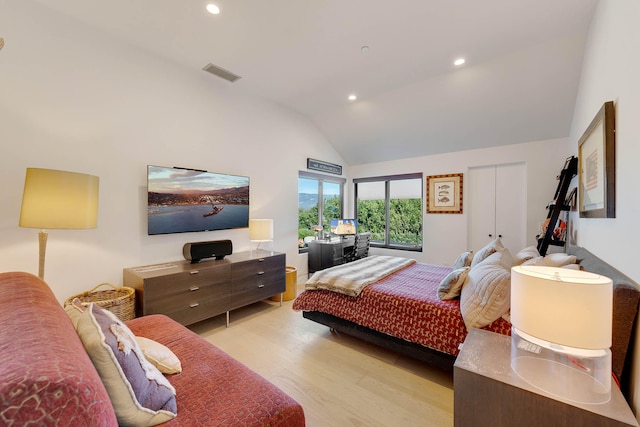 bedroom with vaulted ceiling and light wood-type flooring