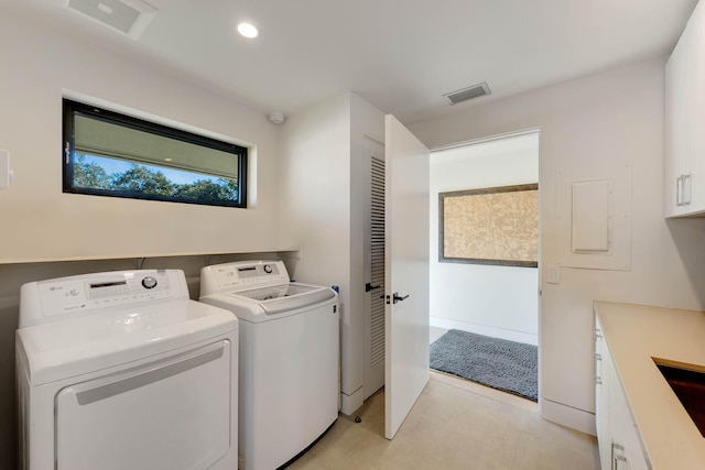 laundry room featuring washing machine and dryer and cabinets