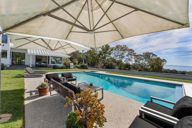 view of pool with outdoor lounge area, a patio, and a lawn