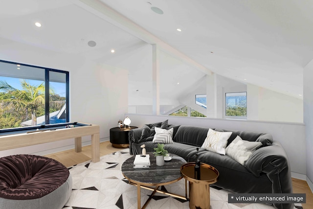 living room with a wealth of natural light and lofted ceiling with beams