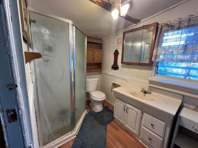 bathroom with vanity, walk in shower, ceiling fan, toilet, and hardwood / wood-style flooring