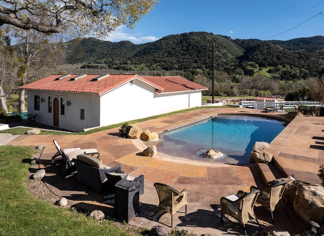 view of pool featuring a patio and a mountain view