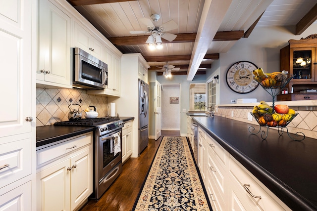 kitchen with ceiling fan, tasteful backsplash, beamed ceiling, dark hardwood / wood-style flooring, and appliances with stainless steel finishes