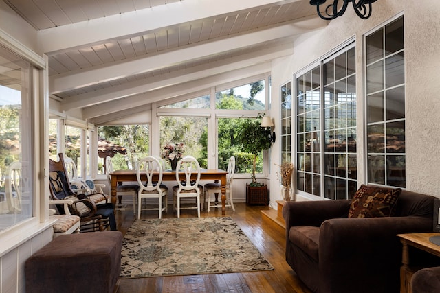 sunroom featuring lofted ceiling with beams and a healthy amount of sunlight