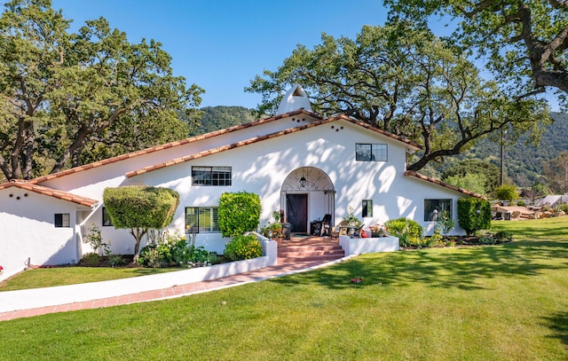 mediterranean / spanish house featuring a front yard