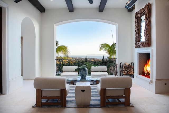 tiled living room featuring ceiling fan and beamed ceiling