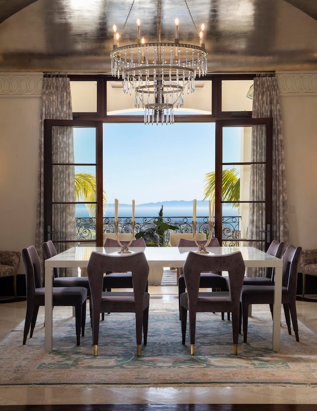 dining room featuring a water view and an inviting chandelier