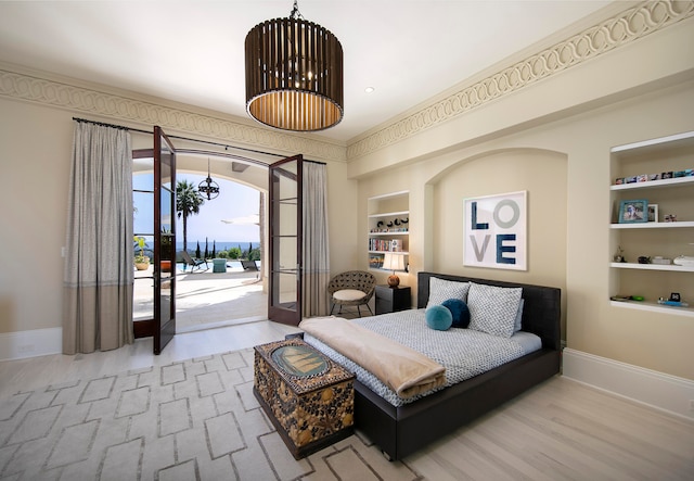 bedroom featuring french doors, a notable chandelier, hardwood / wood-style floors, and access to exterior