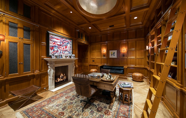 home office with wood walls, a high end fireplace, beam ceiling, coffered ceiling, and ornamental molding