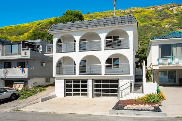 view of front of home with a garage and a balcony