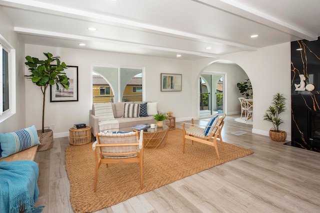 living room with beamed ceiling and wood-type flooring