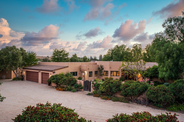 pueblo-style house featuring a garage