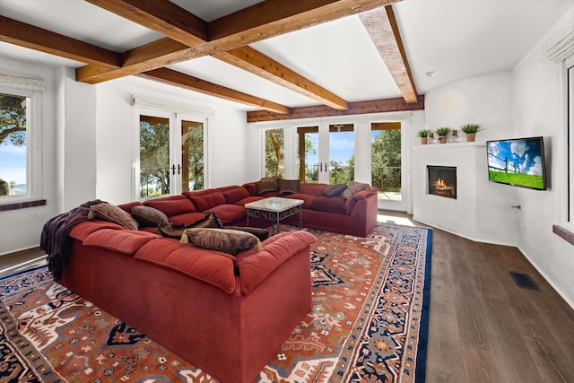 living room with beam ceiling, plenty of natural light, hardwood / wood-style flooring, and french doors