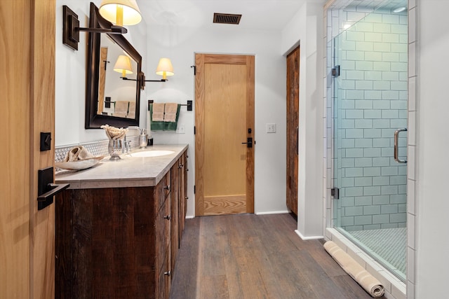 bathroom featuring wood-type flooring, walk in shower, and vanity