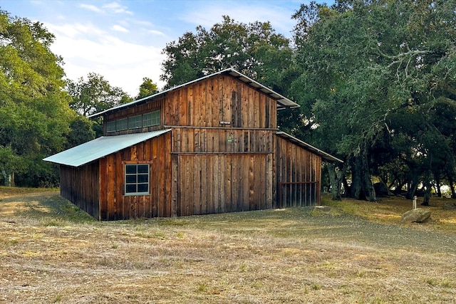 view of home's exterior featuring an outdoor structure and a lawn