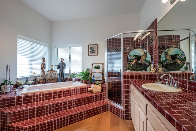 bathroom featuring hardwood / wood-style floors, oversized vanity, and independent shower and bath