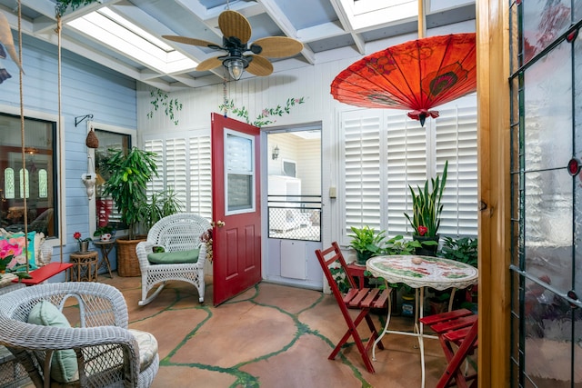 sunroom / solarium with beamed ceiling, coffered ceiling, ceiling fan, and a skylight