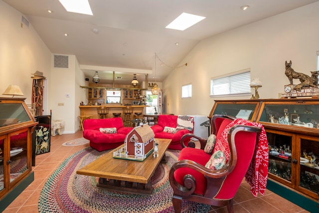 living room with bar area, tile floors, and lofted ceiling