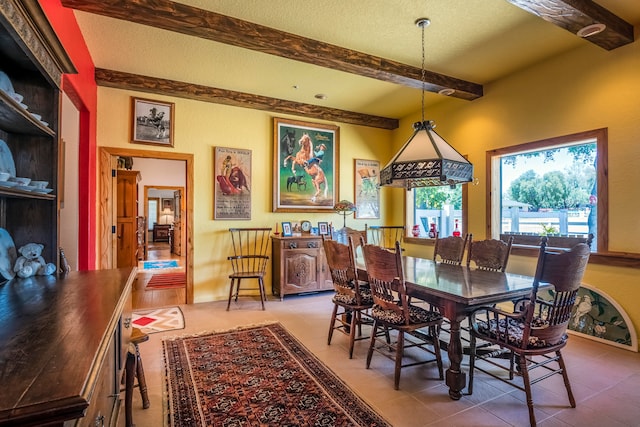 dining room featuring beamed ceiling, a textured ceiling, and light tile floors