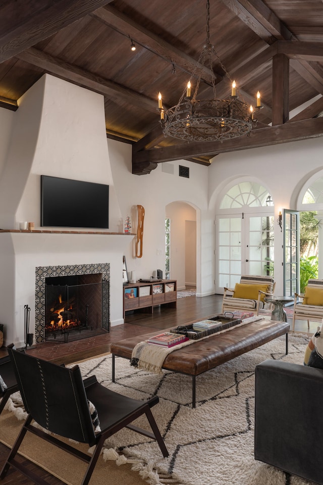 living room with beam ceiling, a tile fireplace, hardwood / wood-style flooring, and wood ceiling