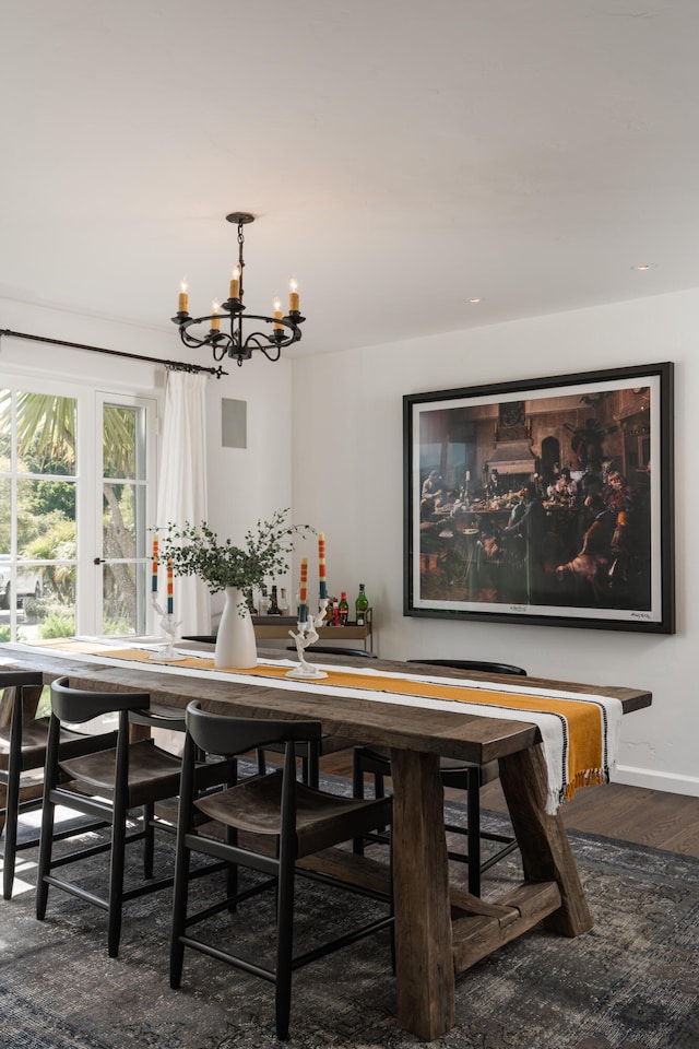 dining space with a notable chandelier and dark hardwood / wood-style flooring