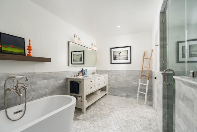 bathroom with tile flooring, separate shower and tub, tile walls, and vanity