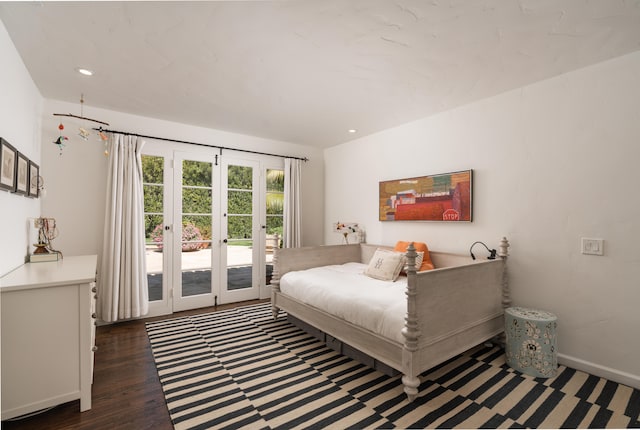 bedroom featuring access to exterior, dark hardwood / wood-style flooring, and french doors