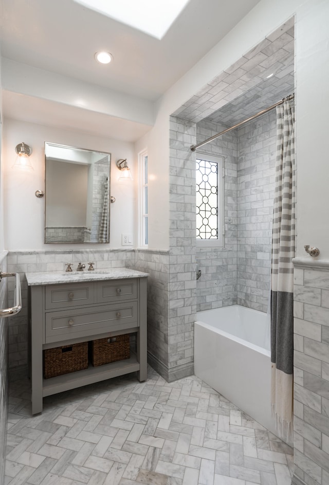 bathroom with vanity with extensive cabinet space, tile walls, and tile flooring