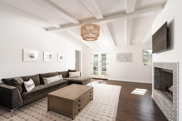 living room with a stone fireplace, french doors, lofted ceiling with beams, and wood-type flooring