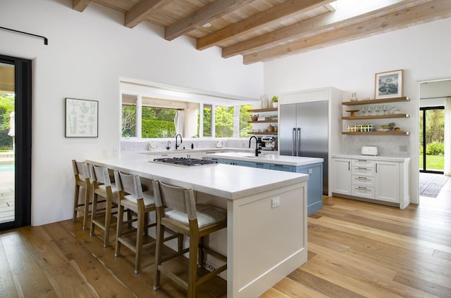 kitchen with wood ceiling, light countertops, beam ceiling, open shelves, and light wood finished floors