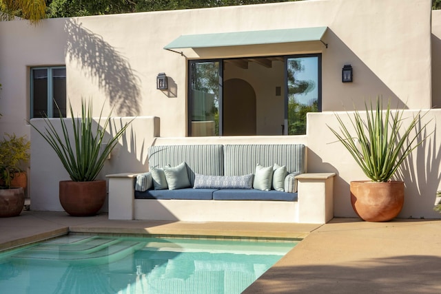 back of house with an outdoor pool, an outdoor hangout area, a patio, and stucco siding