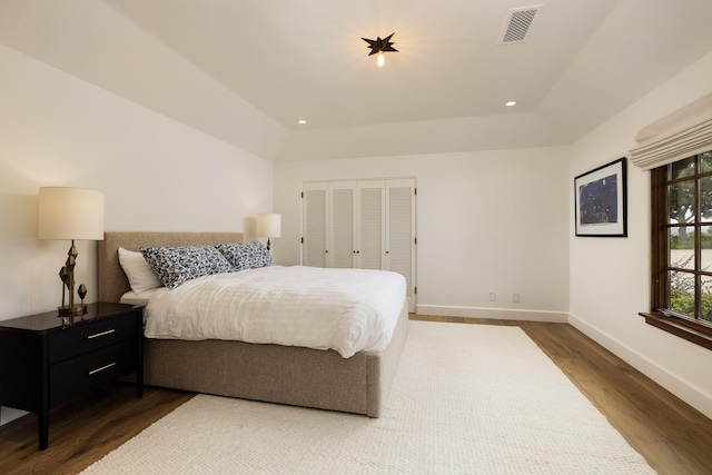 bedroom featuring dark hardwood / wood-style flooring, a closet, and lofted ceiling