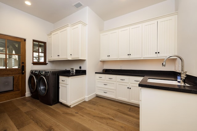 laundry room featuring cabinets, independent washer and dryer, dark hardwood / wood-style flooring, and sink