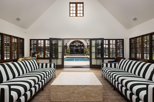 carpeted living room with high vaulted ceiling