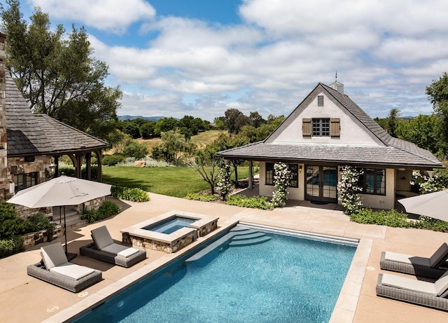 view of pool featuring an in ground hot tub, a patio, and a lawn