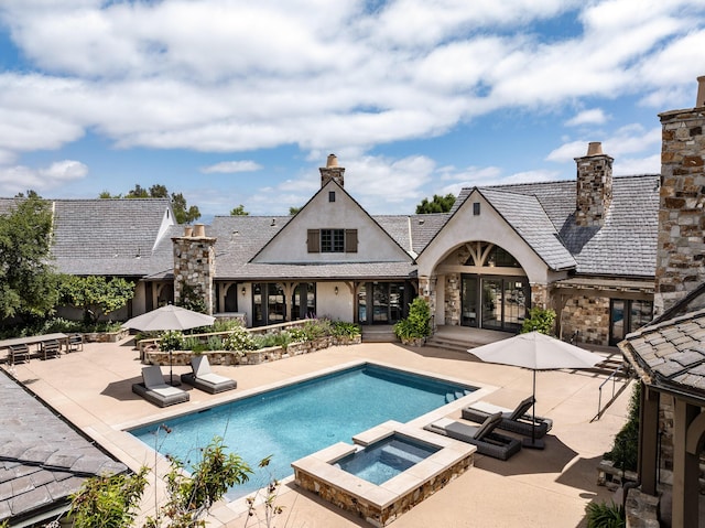 view of swimming pool featuring an in ground hot tub and a patio