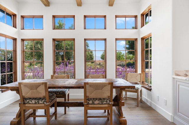 sunroom / solarium featuring beamed ceiling