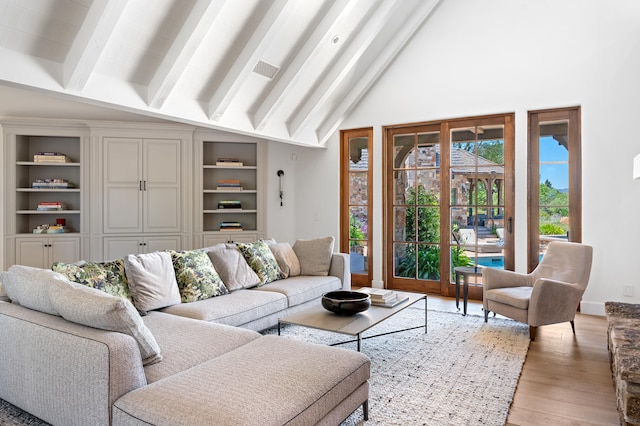 living room with beam ceiling, light wood-type flooring, and high vaulted ceiling