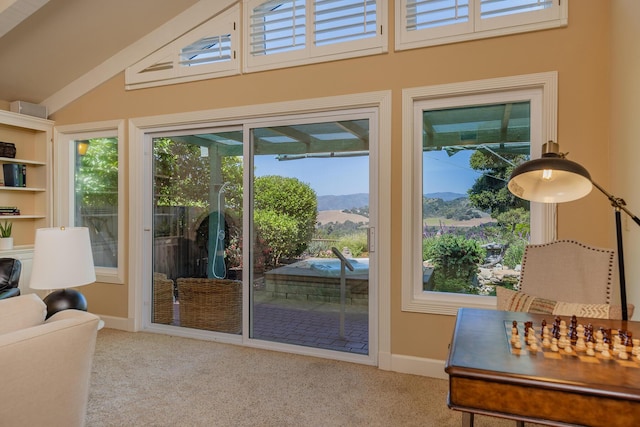 doorway to outside with a mountain view, light carpet, and a wealth of natural light