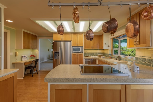 kitchen with pendant lighting, appliances with stainless steel finishes, light brown cabinetry, and backsplash