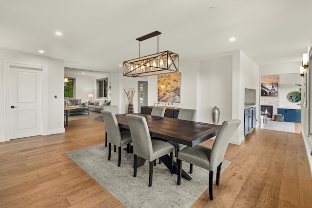 dining space featuring a fireplace and light wood-type flooring