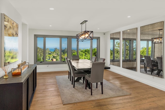 dining area with an inviting chandelier and light hardwood / wood-style floors