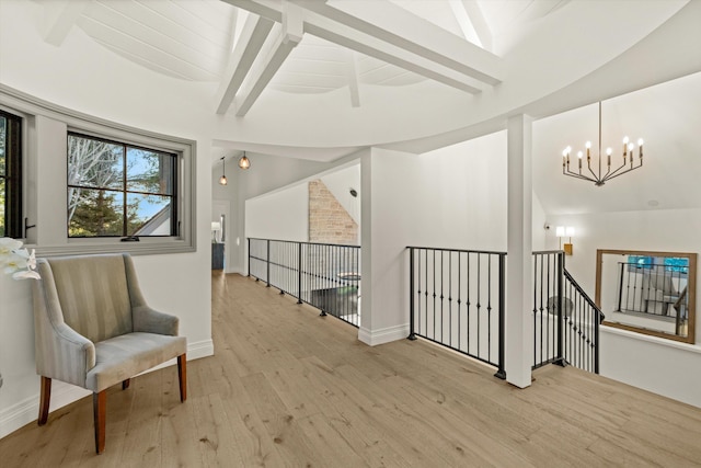 sitting room featuring vaulted ceiling with beams, light hardwood / wood-style floors, and a notable chandelier