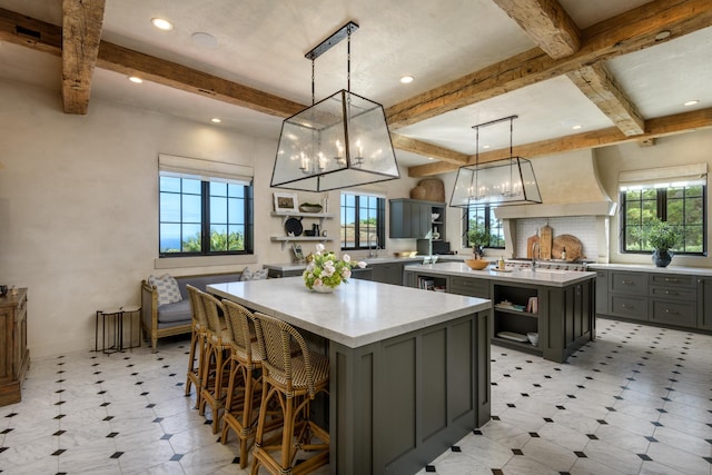 kitchen featuring a center island, decorative light fixtures, gray cabinets, light countertops, and open shelves