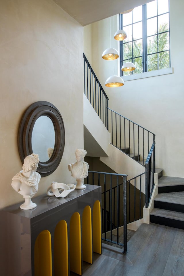 stairway featuring a high ceiling and wood finished floors