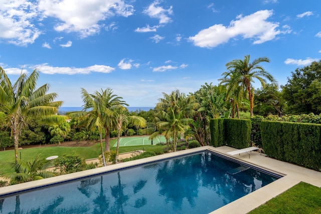 view of swimming pool with a fenced in pool, a yard, and a diving board