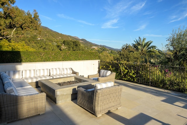 view of patio / terrace with an outdoor living space with a fire pit and a mountain view