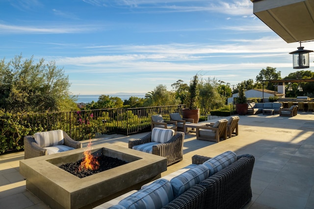 view of patio with an outdoor living space with a fire pit