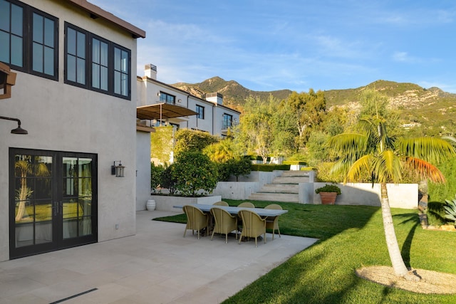 exterior space with a patio area, a mountain view, and french doors