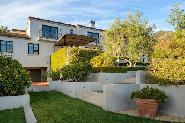 view of yard featuring a balcony, fence, and a mountain view